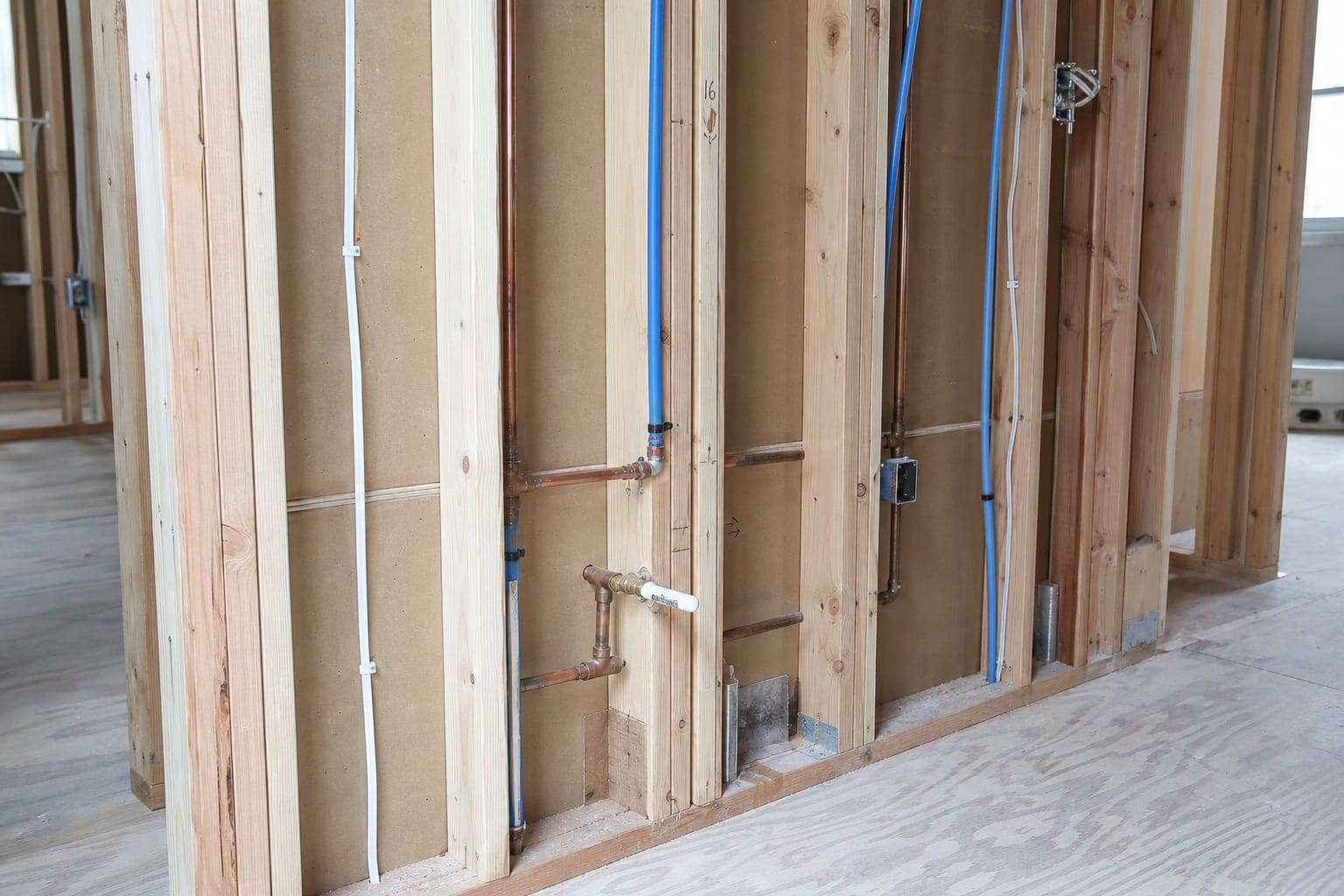 New copper supply lines and wiring in the open sink wall before drywall